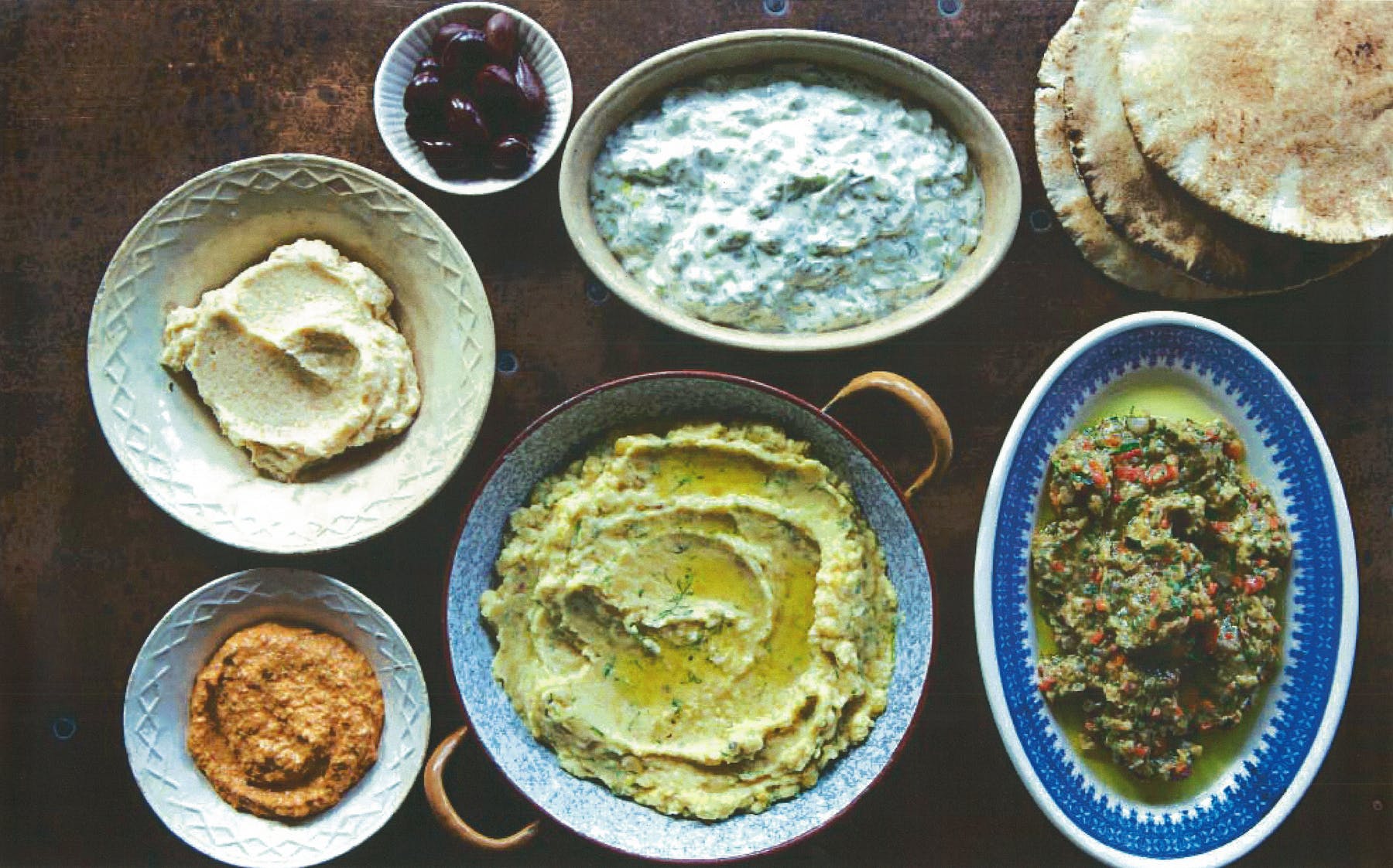 a wooden table topped with plates of food on a plate